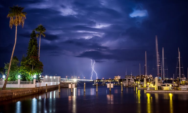 A powerful thunderstorm with lightning at a marina during the evening, showcasing nature's drama.